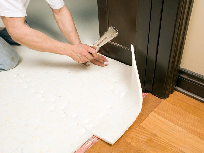 Person installing flooring underlayment - Flooring installation services from B & B Floor Co in Springfield, VA